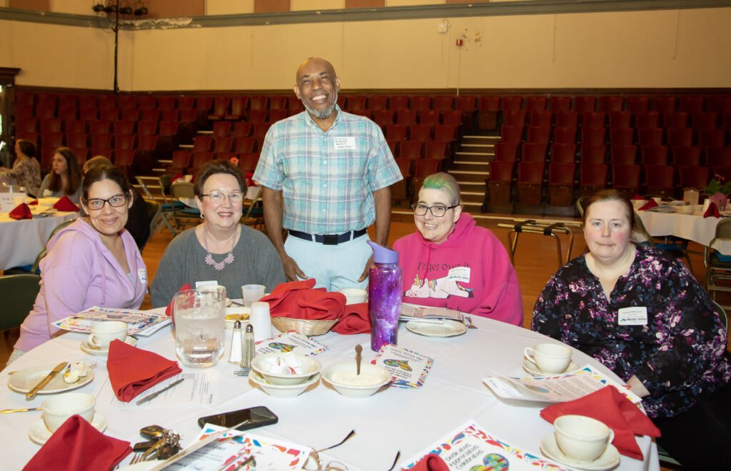 men and women at table smiling at camera