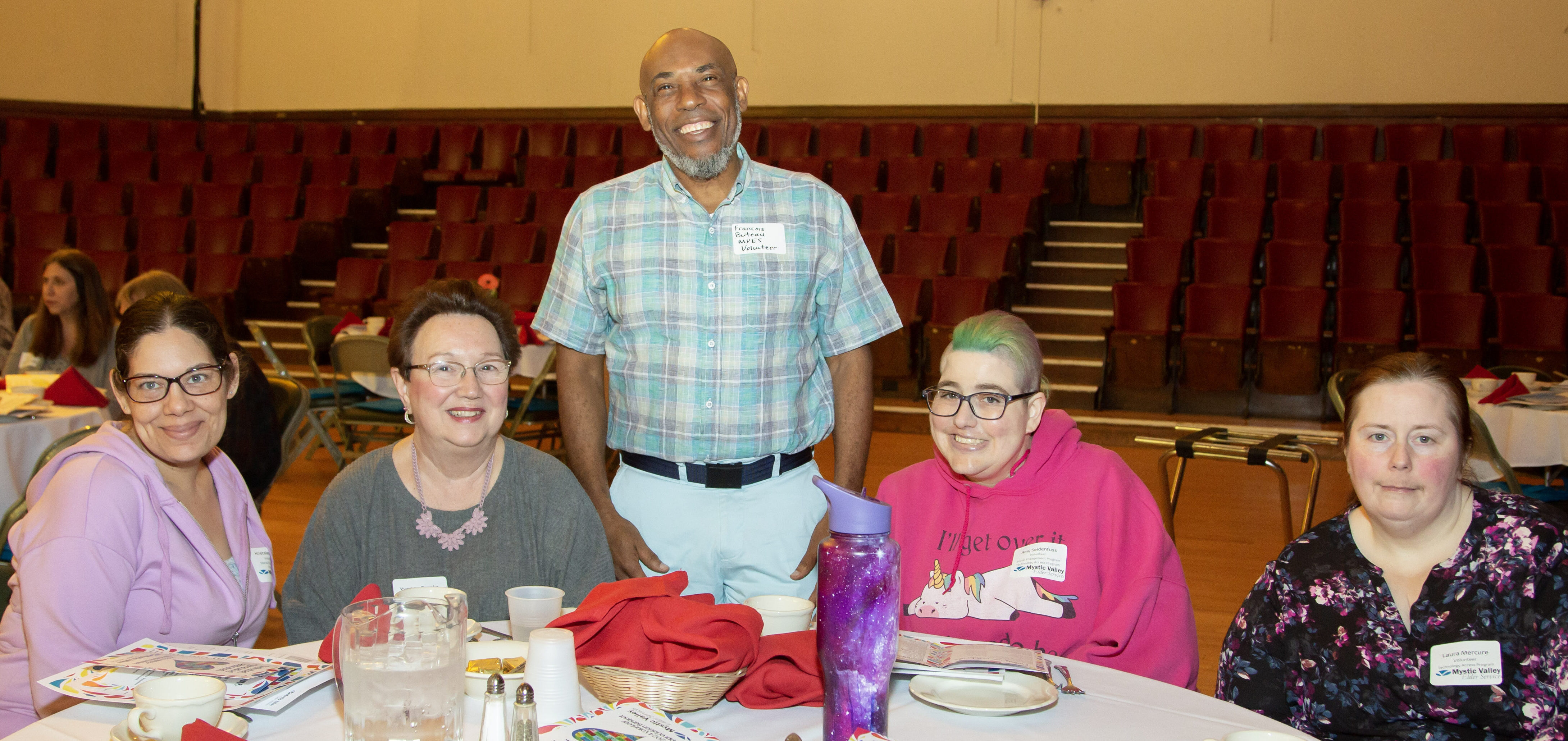 men and women at table smiling at camera